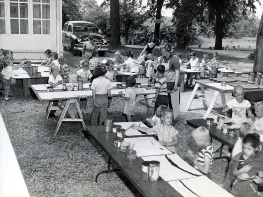 Black and white photo of a children's outdoor painting class