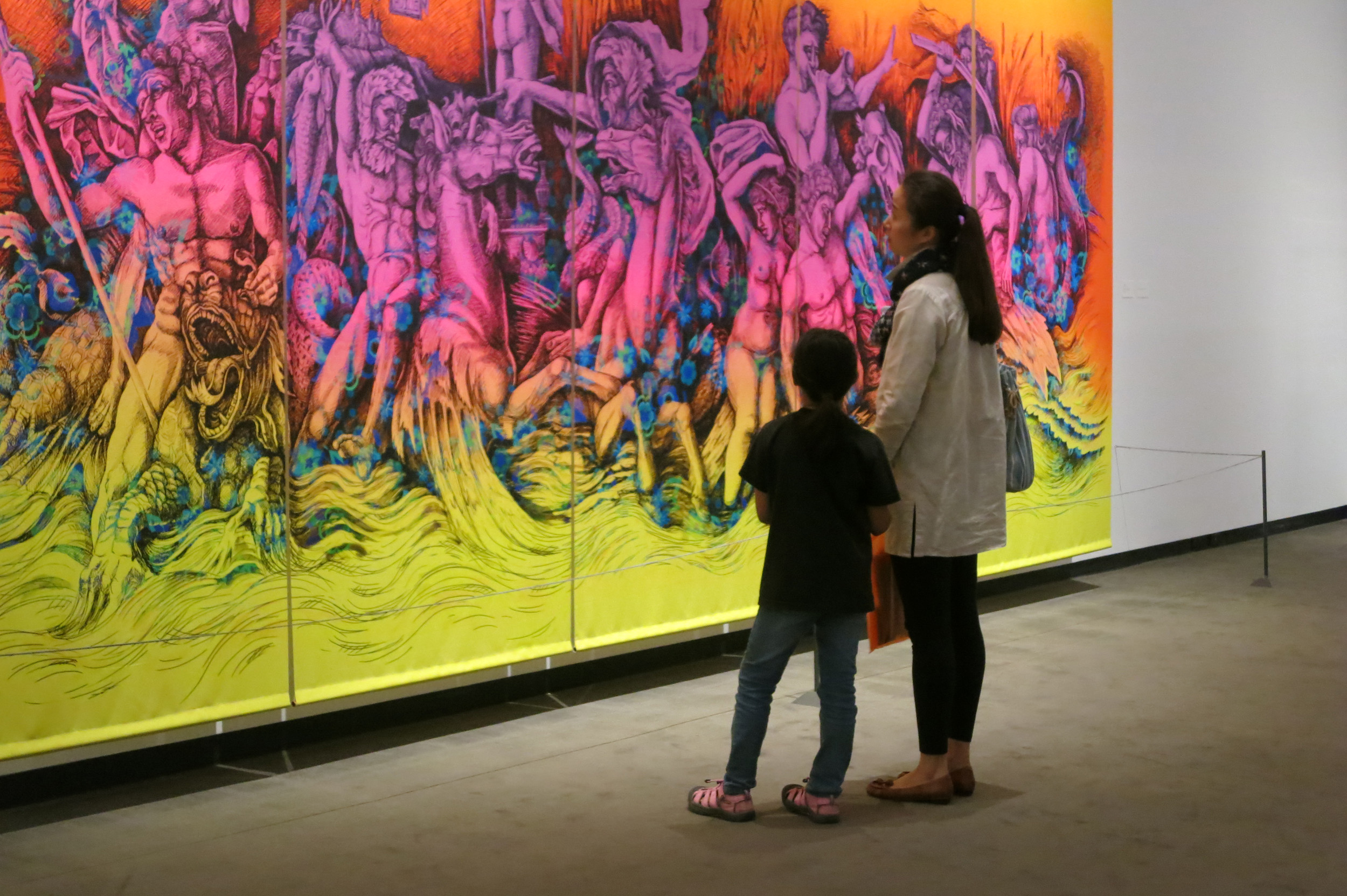 Mother and child looking at brightly colored artwork