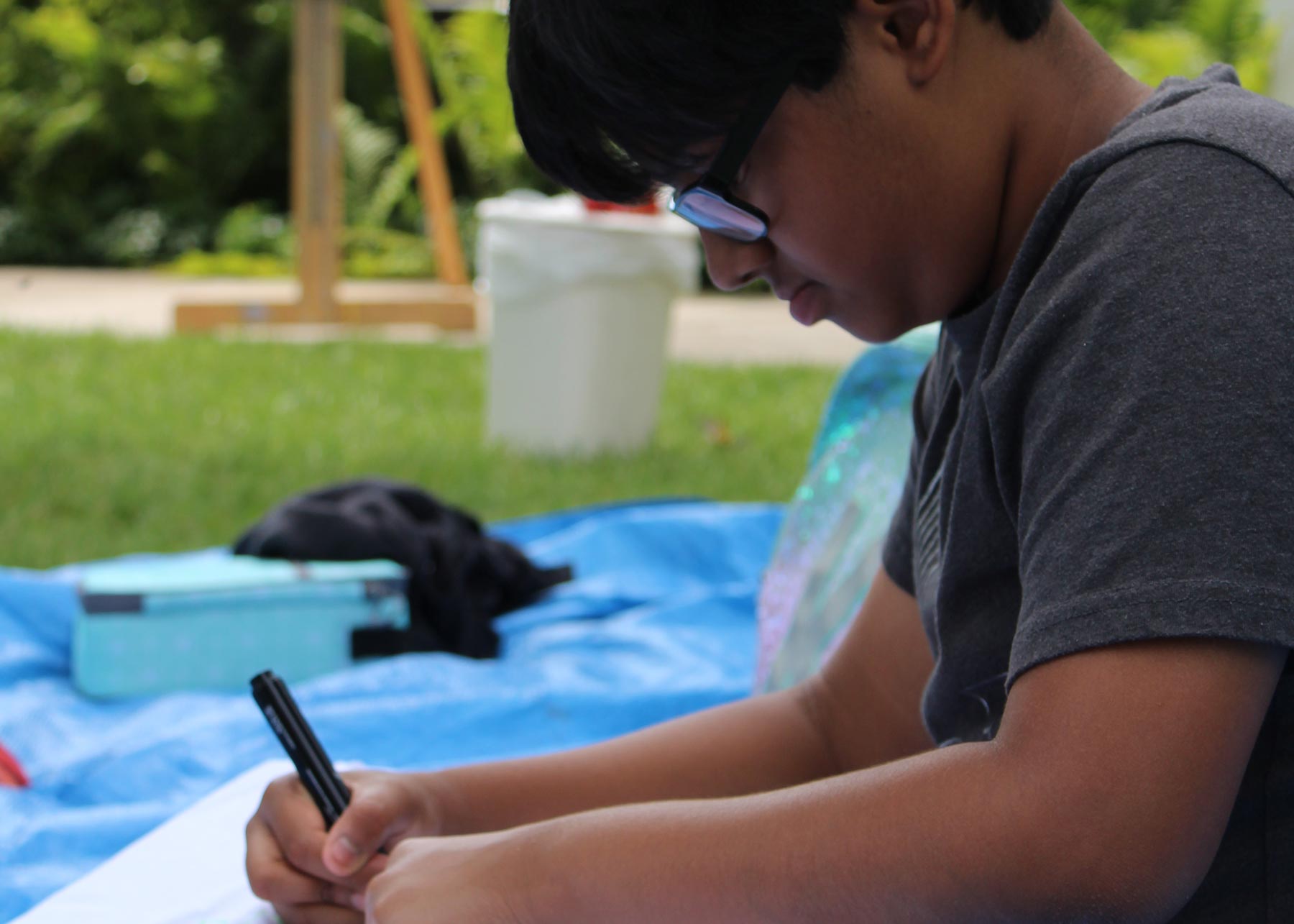 Boy Drawing Outside Camp '17