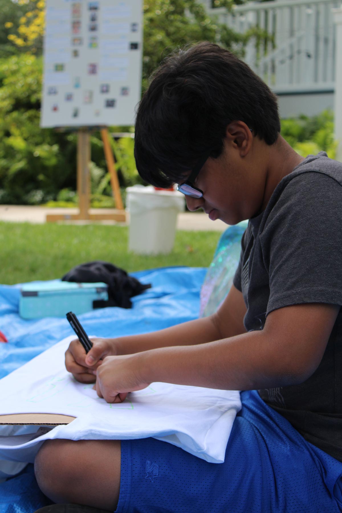 Boy Drawing Outside Camp 17