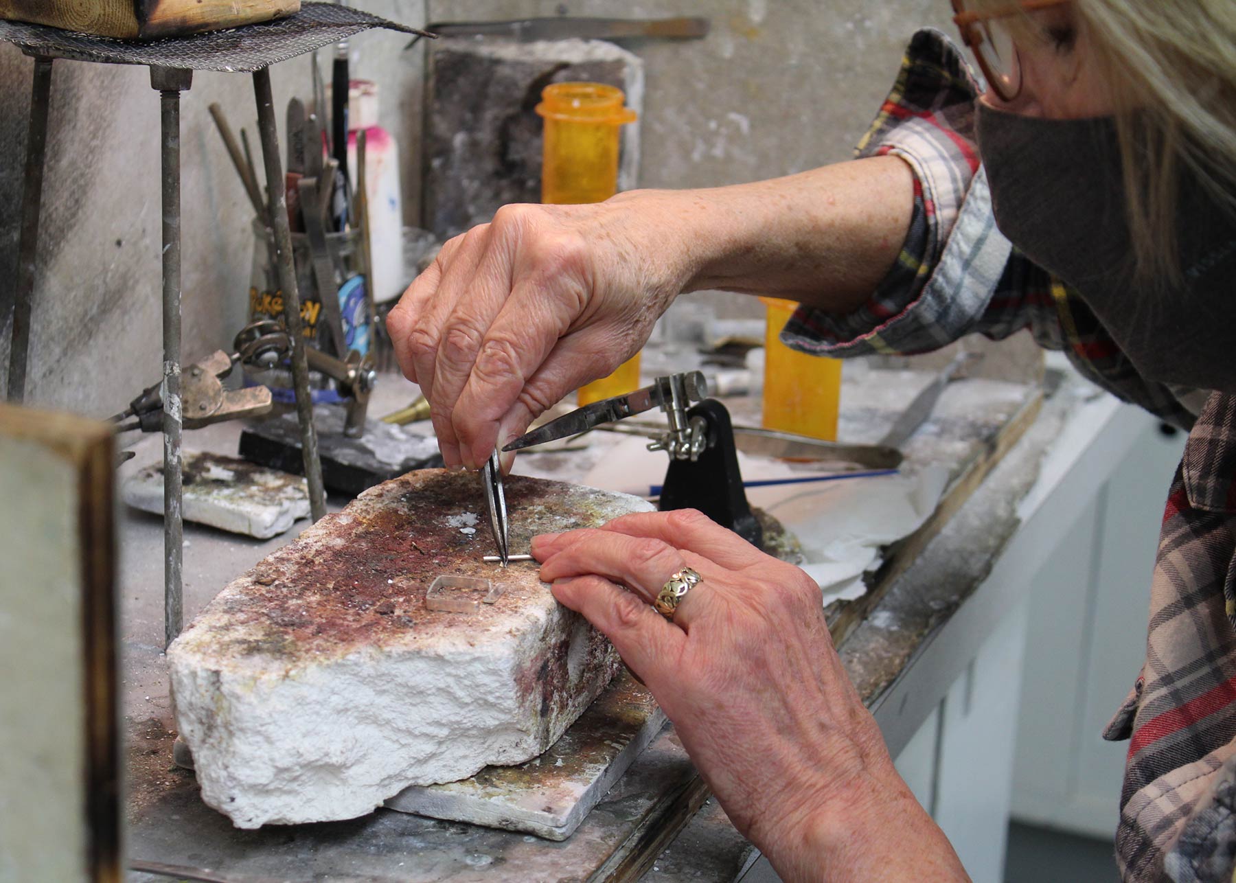 Woman creating jewelry in the Wustum Museum studios