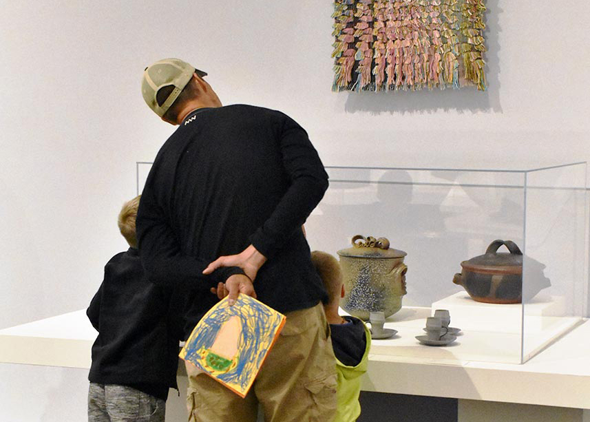 Man with two children viewing artwork in the RAM galleries